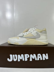 Side profile showing the layered white upper, cream mesh sections, gray Swoosh, forefoot strap, and ribbed cream outsole.