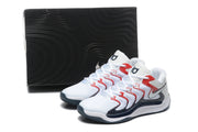 Sneakers displayed beside a black patterned shoe box, showing the white, red, and black color scheme.