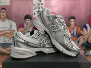 Two silver-tone New Balance 530 sneakers shown in a side and angled view.
