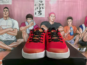 Front view of the red basketball sneakers with black laces, patterned tongue panels, and white layered outsoles.