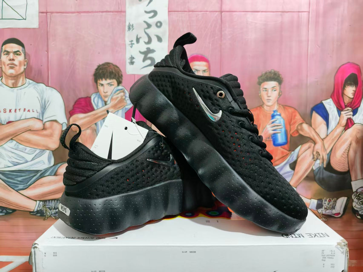 Pair of black Nike sneakers displayed on a Nike box, showing the side profile, perforated uppers, and contrasting Swoosh details.