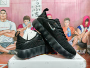 Pair of black Nike sneakers displayed on a Nike box, showing the side profile, perforated uppers, and contrasting Swoosh details.