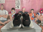 Front view of black and white Jordan-style basketball shoes with red Jumpman accents