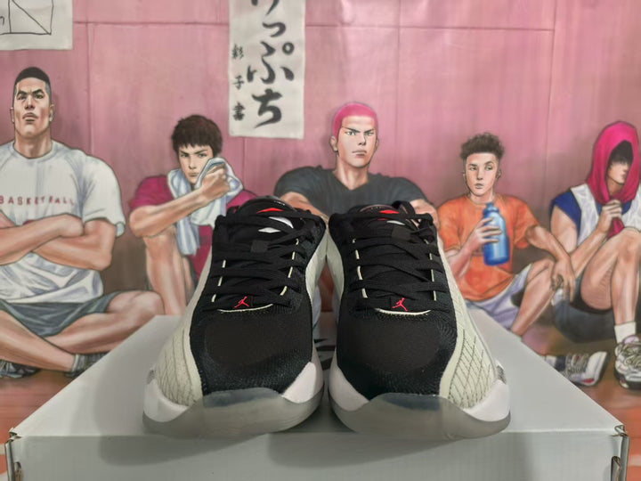 Front view of black and white Jordan-style basketball shoes with red Jumpman accents