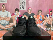 Front view of the black Nike sneaker pair, showing the textured toe boxes, laces and tongue branding.