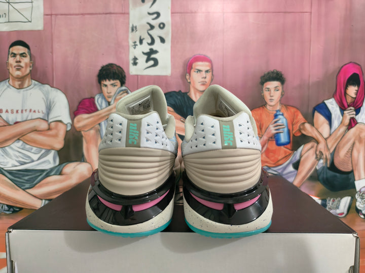 Rear view of gray-blue Nike basketball shoes with pink accents and turquoise outsole edges.