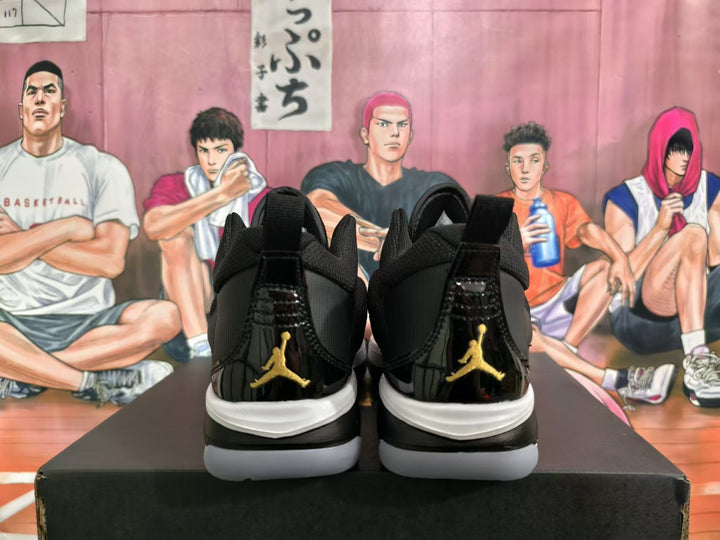 Rear view of black high-top basketball sneakers with gold-colored Jumpman logos and white midsoles.