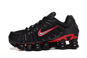 Side view of a black Nike Shox TL sneaker with red accents and segmented sole columns.