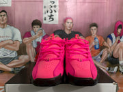Front view of bright pink Nike basketball shoes with perforated toe panels, pink laces, and black outsole sections.