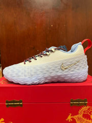 Side view of a Nike S.T. Charge sneaker in white and blue with patterned laces, metallic Swoosh and layered white sole.