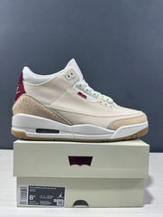 Side view of a cream and red Jordan Air Jordan 3 Retro sneaker beside its box; the box label shows UK 7.5, CM 26.5, EU 42, and style code IR0910 400.
