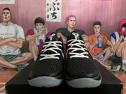 Front view of black basketball sneakers with white laces and textured uppers.