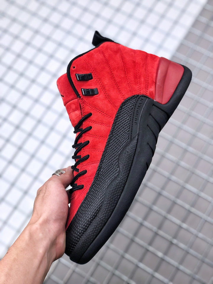 Close-up side view of a red and black Jordan high-top sneaker with black laces and a textured black side panel.