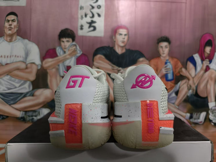 Rear view of white Nike basketball sneakers with pink heel branding and coral heel accents on a shoebox.