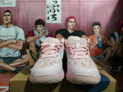 Front view of pink and white ASICS basketball shoes with pale blue side details