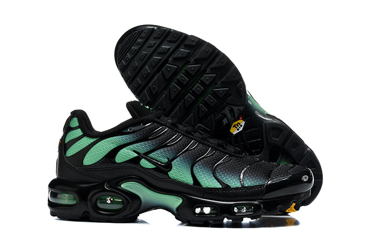 Nike Air Max Plus sneakers showing the black outsole and black-and-green side profile.