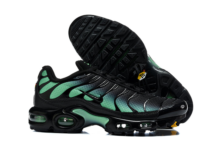 Nike Air Max Plus sneakers showing the black outsole and black-and-green side profile.