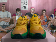 Front view of yellow lace-up sneakers with green trim