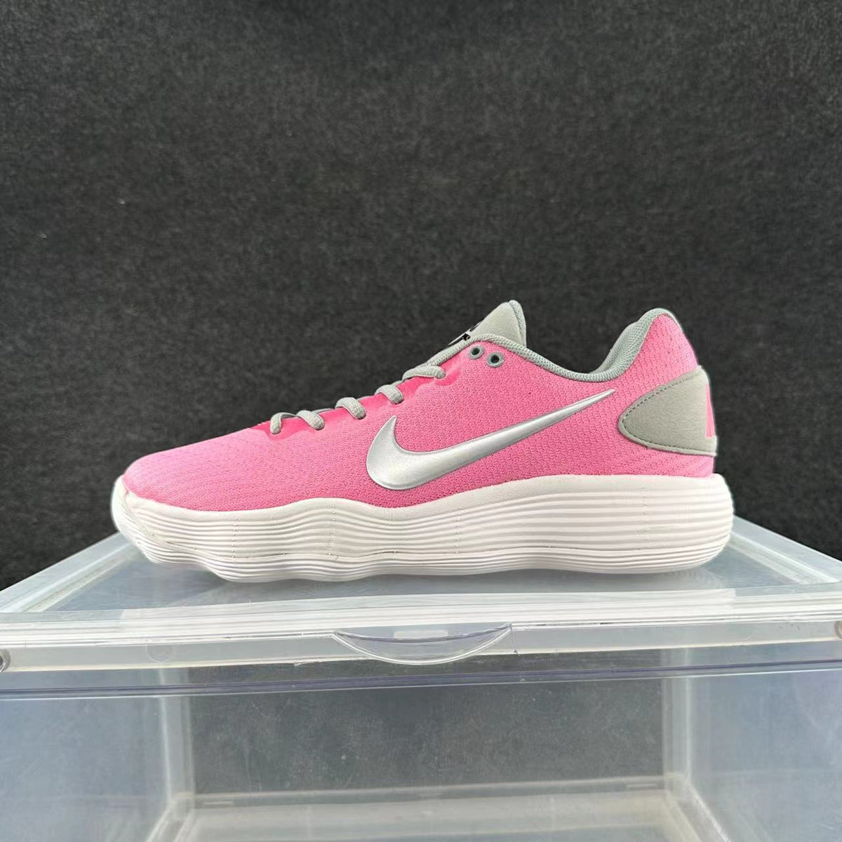 Pink and grey Nike low-top sneaker with silver-tone Swoosh and white ridged sole