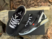Top and side view of the black sneakers showing padded collars, white laces, textured uppers, and Kobe logo details.