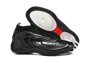 Black basketball shoes shown from the side and outsole, with white circular traction zones and a red central outsole accent.