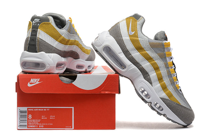 Nike Air Max 95 TT sneakers in grey, white and yellow beside a box labeled DM0011-010; the box shows size 8.