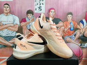 Three-quarter view showing the peach pink Nike sneakers, black Swoosh branding, pink laces, and heel details.