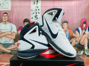 Pair of white, navy, and red Nike LeBron high-top basketball shoes, shown from the side