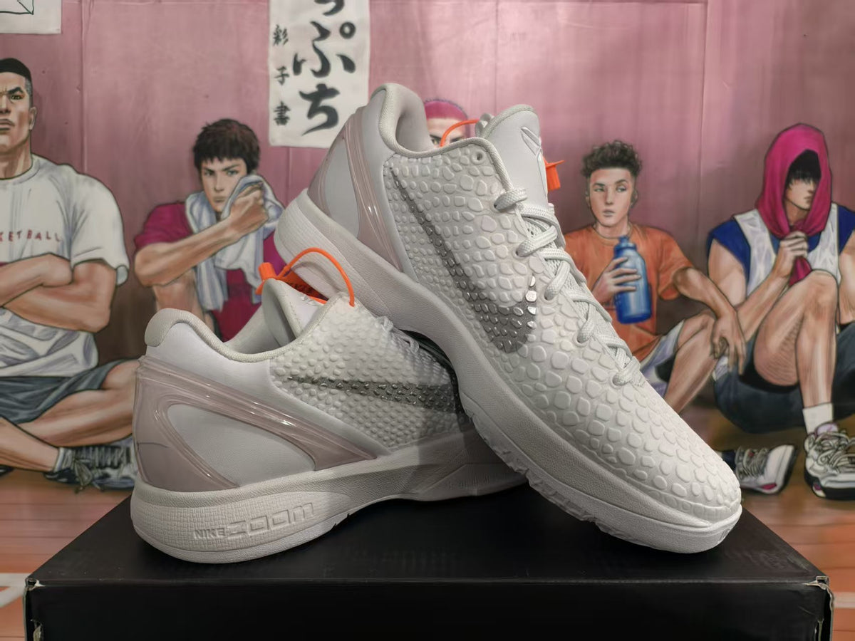 Pair of white and gray Nike Zoom basketball sneakers shown from a three-quarter angle, with textured uppers and gray side swooshes.