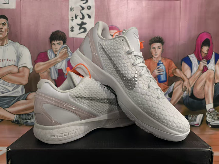 Pair of white and gray Nike Zoom basketball sneakers shown from a three-quarter angle, with textured uppers and gray side swooshes.