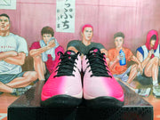Front view showing black laces, textured pink and white uppers, and black outsoles.
