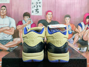 Rear view of pale yellow and blue Nike basketball shoes with black heel accents.