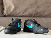 Front view of the pair showing black laces, turquoise side branding, textured toe overlays, and dark midsoles.