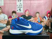 Side view of blue and white Nike Kobe 8 basketball sneakers showing the textured upper, white Swoosh, red number 8 and white midsole.