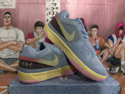 Angled view of the blue and gray basketball sneakers highlighting the mesh upper, Swoosh, perforated toe area, and layered colorful sole.