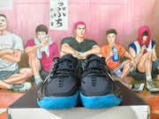 Front view of the black basketball shoes showing the laces and blue outsole.