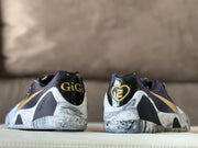 Rear view showing gold “GiGi” and heart-shaped “2” heel graphics on the dark heel panels.