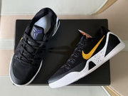 Top view showing the black laces, tongue emblem, gold Swoosh, and white outsole edge.
