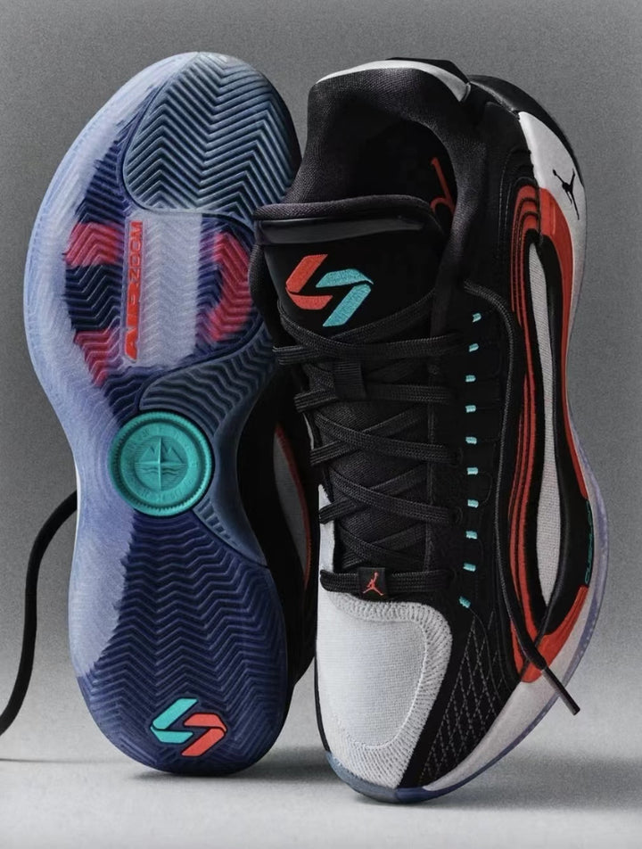 Pair of black Jordan basketball sneakers with red, white, and teal accents, shown with one shoe displaying its translucent patterned outsole.