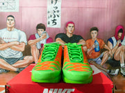 Front view of orange and green Nike Air Max Plus sneakers