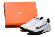 White and black Nike basketball shoes pictured beside an orange shoe box