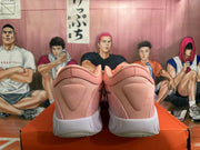Rear view of pink and white Nike basketball shoes on an orange box