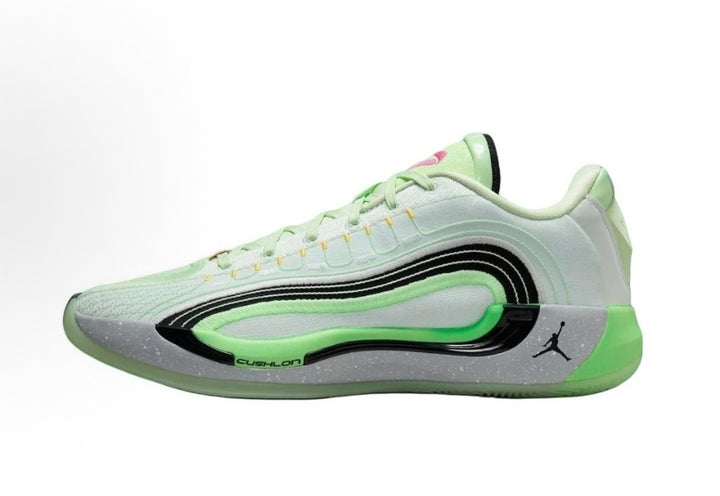 Side view of pale white and green Jordan Luka basketball sneakers with black detailing, a speckled gray midsole, and green outsole.