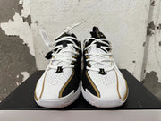 Front view of white-and-black Nike basketball shoes with white laces and gold trim.