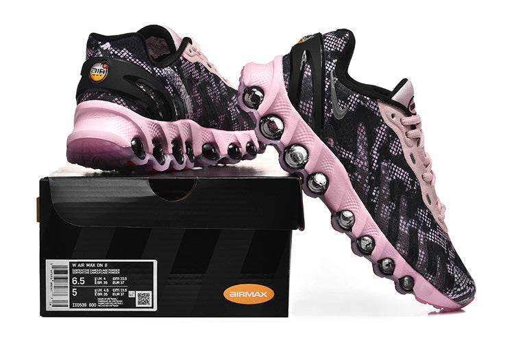 Pair of black and pink Nike Air Max DN8 sneakers displayed with a box label.