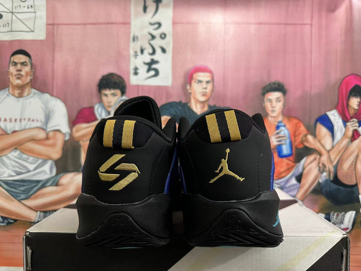 Rear view of black Jordan basketball shoes with gold graphics and blue side accents.