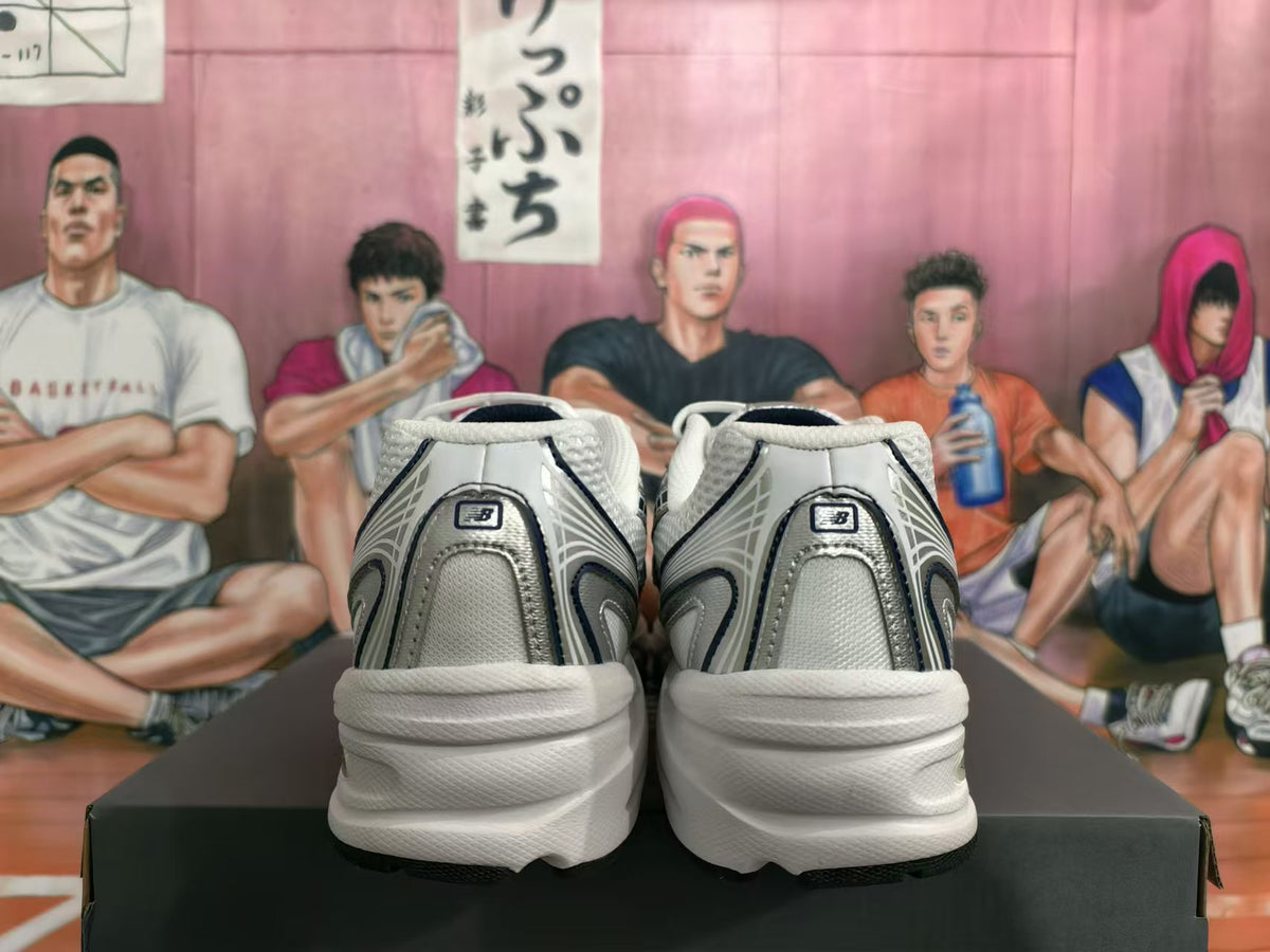 Rear view of silver-tone New Balance 530 sneakers with light-colored layered soles.