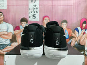 Rear view of black basketball shoes with white outsoles and GT markings on the heels