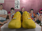 Front view of yellow lace-up sneakers with tonal laces, white decorative beads, and textured uppers.