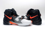 Pair of black, white, and orange Nike high-top basketball shoes shown from the rear and side.